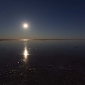 Lake Eyre full moon setting reflected on water